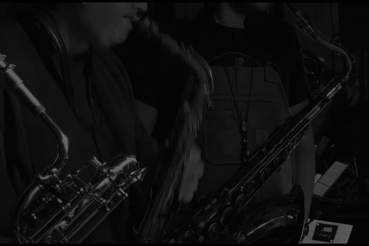 Two musicians playing brass instruments in a close-up shot.